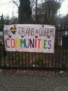 A banner on display at International Day Against Homophobia and Transphobia rally reads We love trans and queer communities